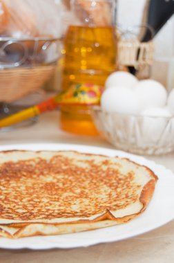 Plate with pancakes on a table clipart