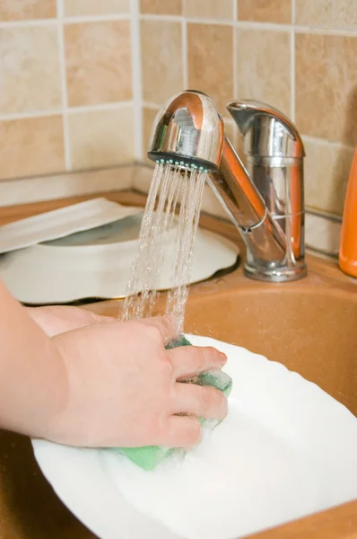La mujer lava la vajilla en la cocina —  Fotos de Stock
