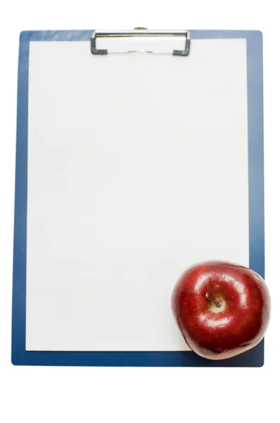 Portapapeles en blanco y una manzana — Foto de Stock