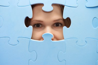 The girl spies through a blue puzzle clipart