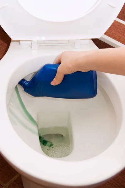 Main nettoie un bol de toilette dans une salle de bain — Photo