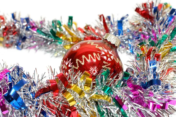Christmas tinsel with a red toy — Stock Photo, Image