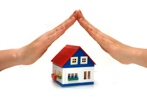 Hands over a small house — Stock Photo, Image