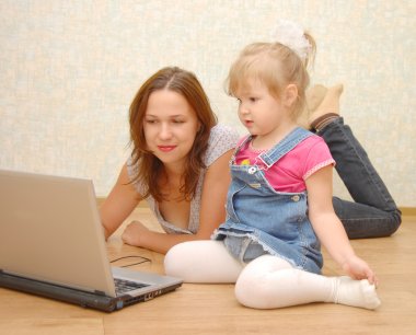Anne ve kızı dizüstü bilgisayar kullanıyor.