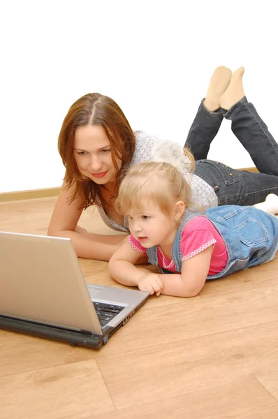母亲和女儿一起在木地板上的笔记本电脑 — 图库照片