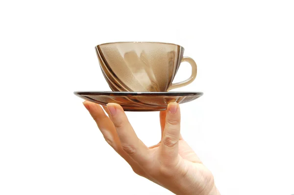 Empty glass cup with a saucer in a female hand — Stock Photo, Image