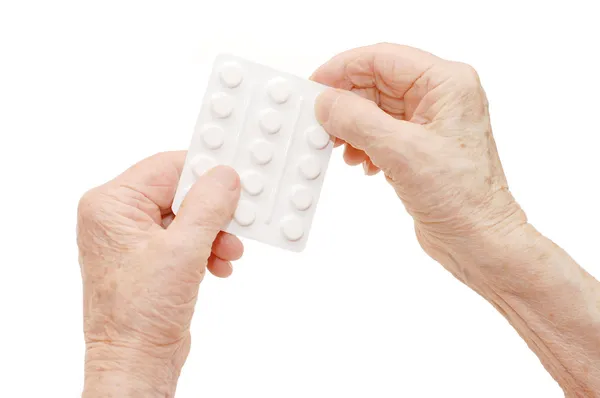 Руки старших з таблетками ізольовані — стокове фото