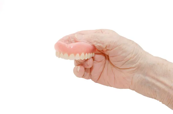 Mão sênior com prótese dentária — Fotografia de Stock