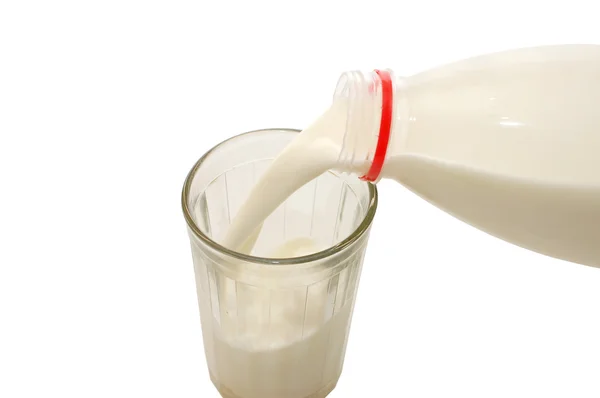 Gieten van fles in een glas melk — Stockfoto