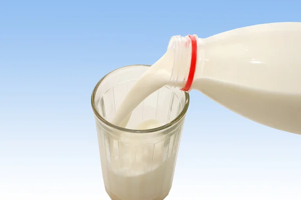 ミルクのボトルからグラスに注ぐ — ストック写真