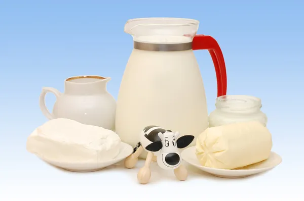 Conjunto de produtos lácteos e uma vaca de brinquedo — Fotografia de Stock