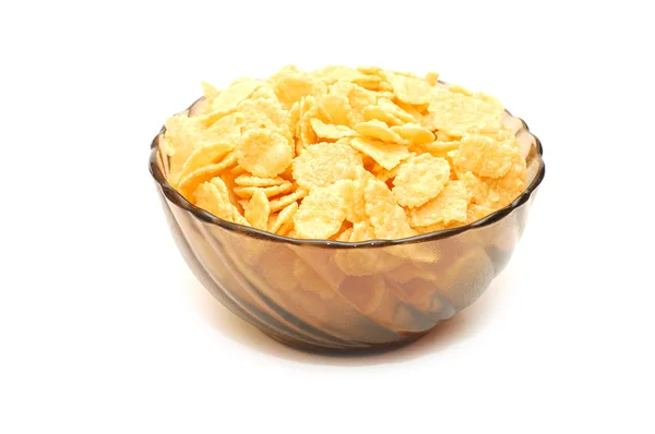 Transparent bowl with corn flakes on white backg — Stock Photo, Image