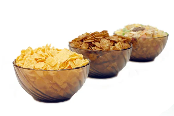 Três xícaras com flocos de milho diferentes — Fotografia de Stock