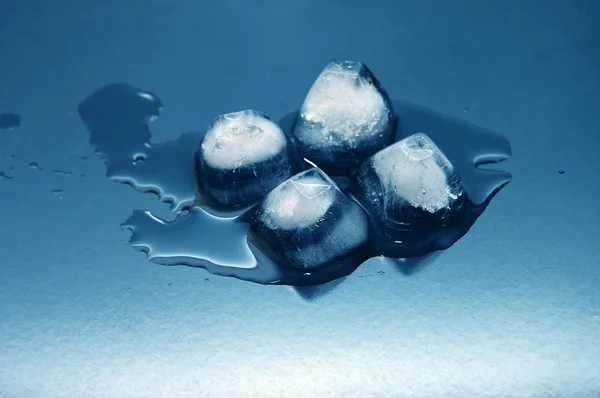 Kostky barevné ledu rozpustí ve vodě na reflexe — Stock fotografie