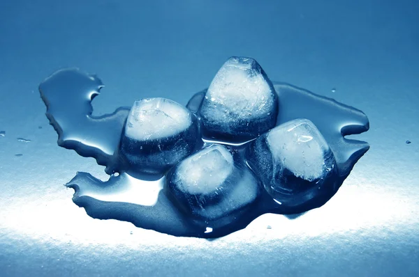Cubi di ghiaccio colorati sciolti in acqua su riflessione — Foto Stock