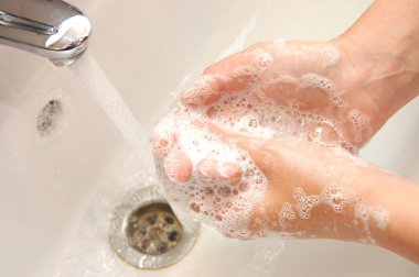 Woman washing hand under running clipart