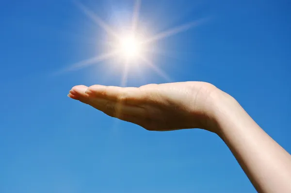 Γυναικείο χέρι αγγίζει τον ήλιο — Φωτογραφία Αρχείου