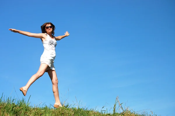 Genç bir kadın karşı güzel gökyüzü atlama — Stok fotoğraf
