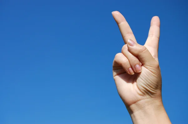 Victory sign against blue sky — Stock Photo, Image