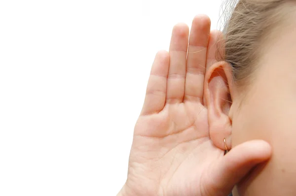 Flicka lyssna med sin hand på ett öra — Stockfoto