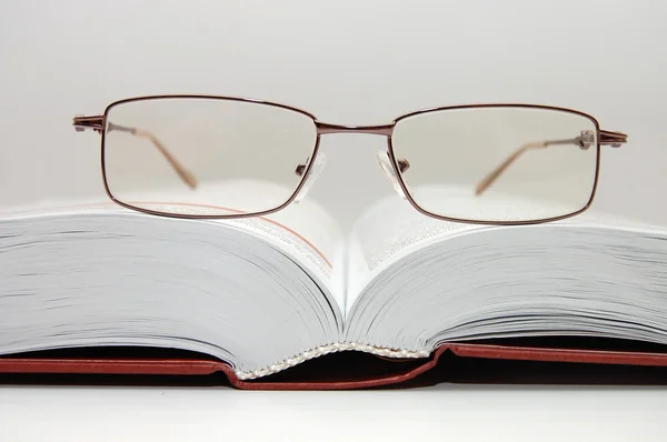 Brýle na otevřené knize — Stock fotografie