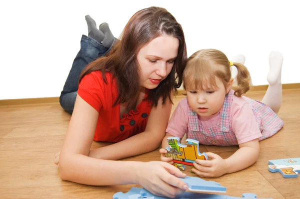 Daughter and her mother solving puzzle — Stock Photo, Image
