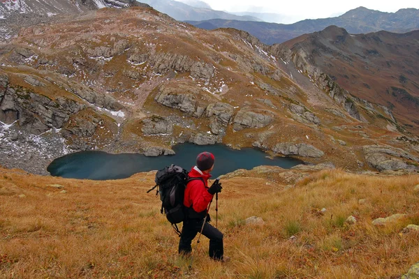 Hiker in the mountains watching a lake — Stock Photo, Image