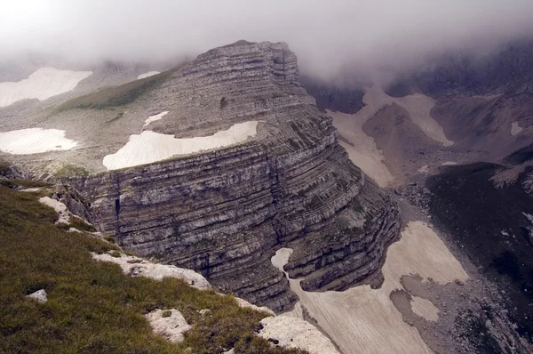 Ein Felsen, der aus dicken Wolken hervorlugt — Stockfoto