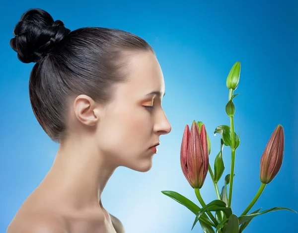 Woman with the flower by red lily. — Stock Photo, Image