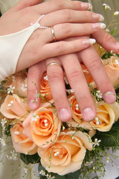 Две руки на свадебном платье — стоковое фото