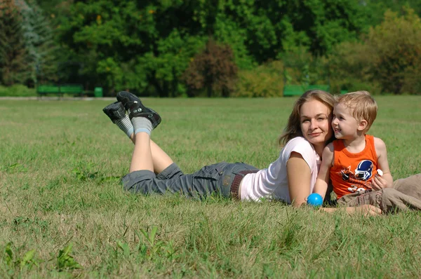 Mother and son on the green grass — Stock Photo, Image