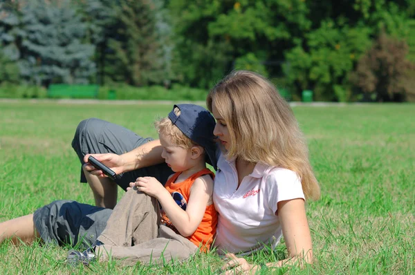 Mother and son on the green grass — Stock Photo, Image