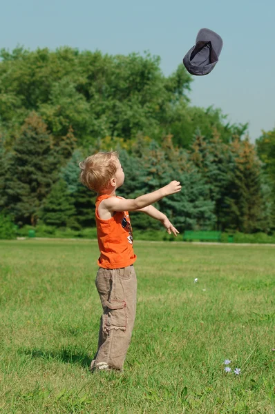 Little boy is tossing his cap — Stock Photo, Image
