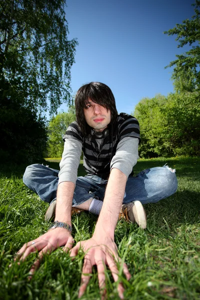 stock image Young man sitting on the grass. Summer