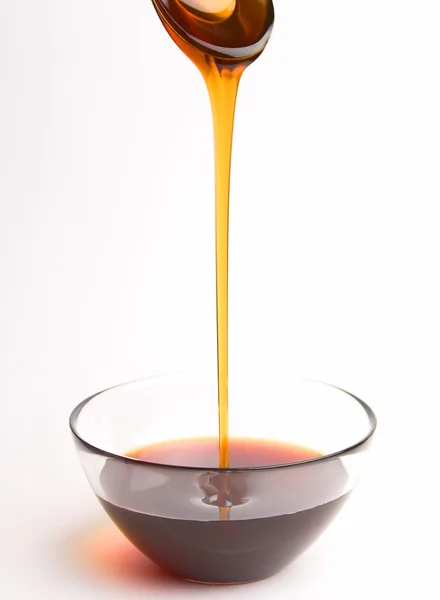 Honey pouring from the spoon — Stock Photo, Image