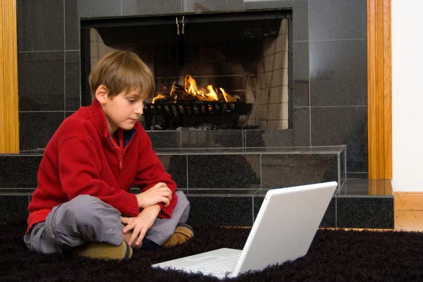 暖炉のコンピューター上での少年 — ストック写真