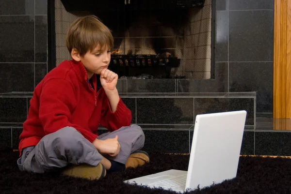 暖炉のコンピューター上での少年 — ストック写真