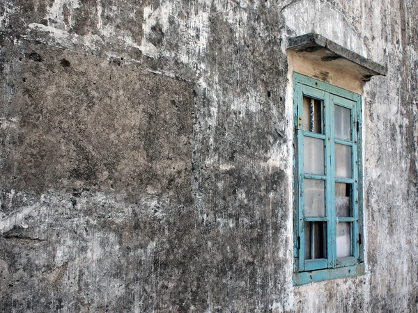 stock image An old broken window on grey wall