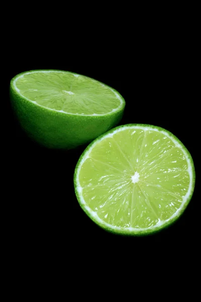 Green limes on black background — Stock Photo, Image
