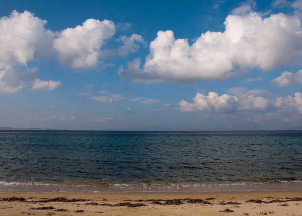 Пляж з блакитним морем і небесними хмарами — стокове фото