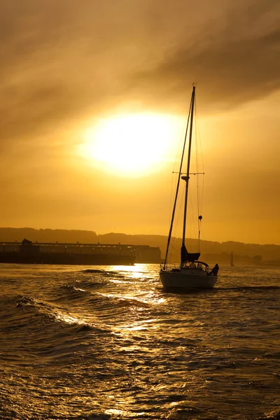 Sunset at sea with yacht silhouette — Stock Photo, Image