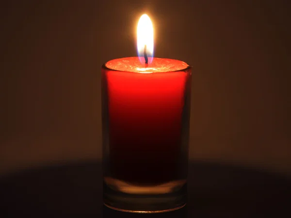 La candela rossa che brucia nella piena oscurità — Foto Stock
