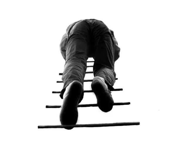 Mann klettert eine Leiter hinauf, isoliert auf einem — Stockfoto