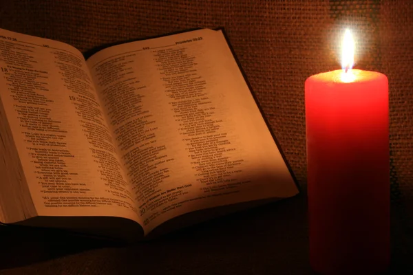 Svíčka a kniha v temnotě — Stock fotografie