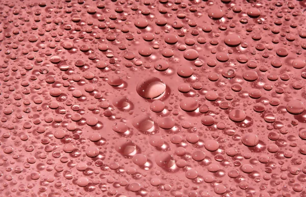 Капли воды на красном — стоковое фото
