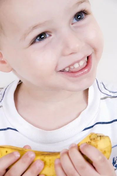 Nahaufnahme eines lächelnden Jungen mit Banane — Stockfoto