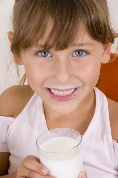 Menina sorridente segurando copo de leite — Fotografia de Stock