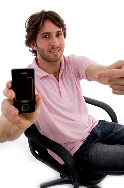 Jeune homme assis montrant mobile — Photo