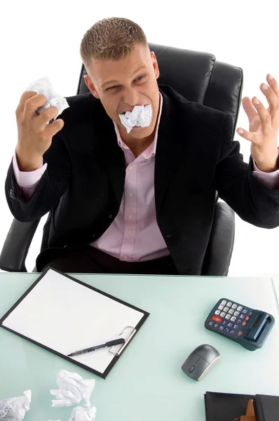 Young angry businessman eating paper — Stock Photo, Image