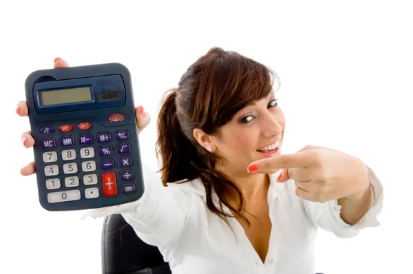 Smiling woman pointing at calculator — Stock Photo, Image
